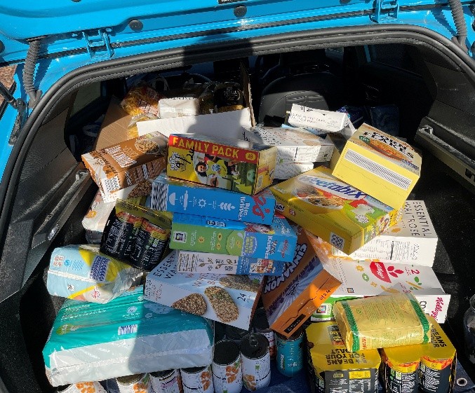 A car boot filled with donated cereal, tinned food and household goods for emergency food parcels